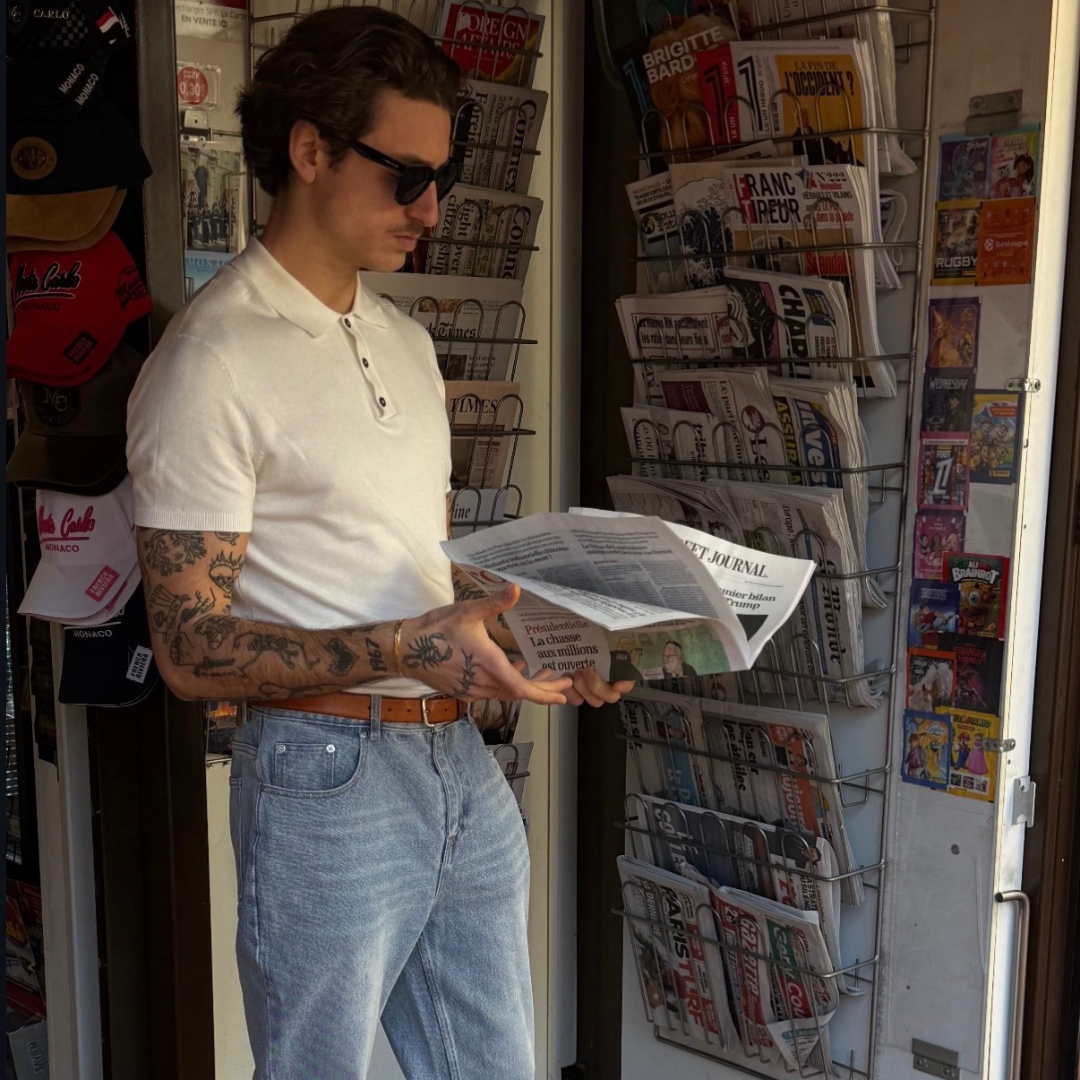 man reading news paper tattoo on arm and wearing monateo jewelry