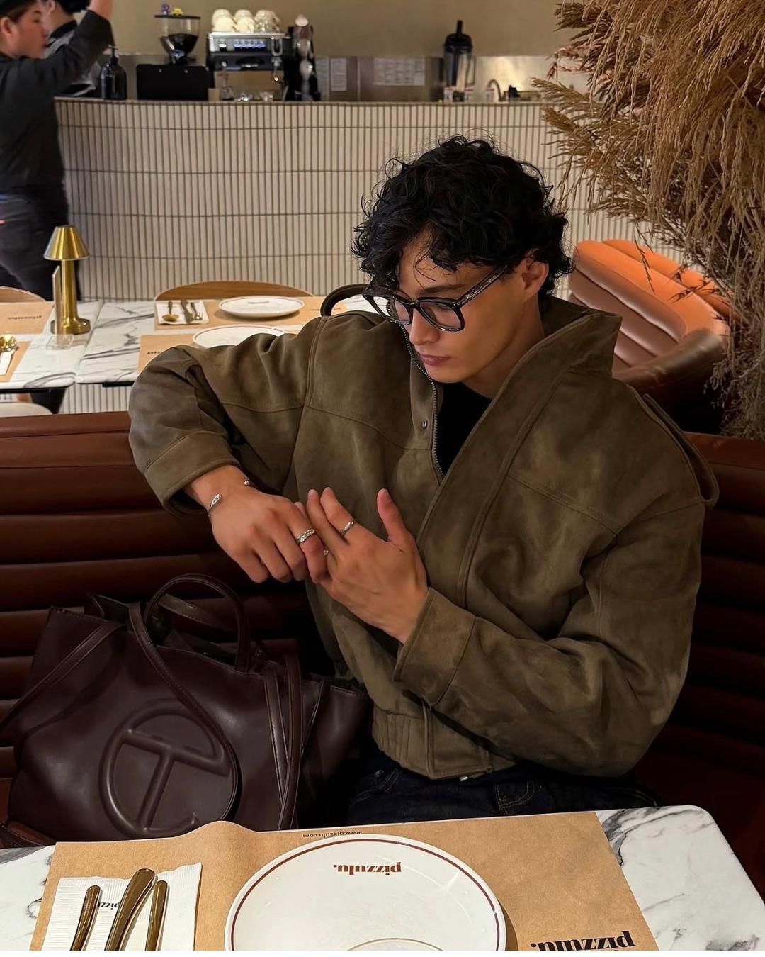 man in a restaurant wearing monateo jewelry