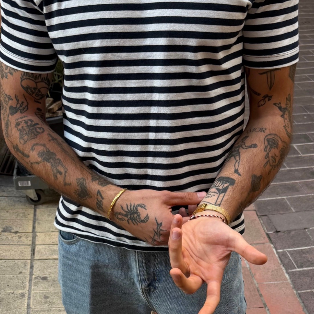 french influenceur man, wearing marinière shirt and monateo jewelry, tattoo on his arm