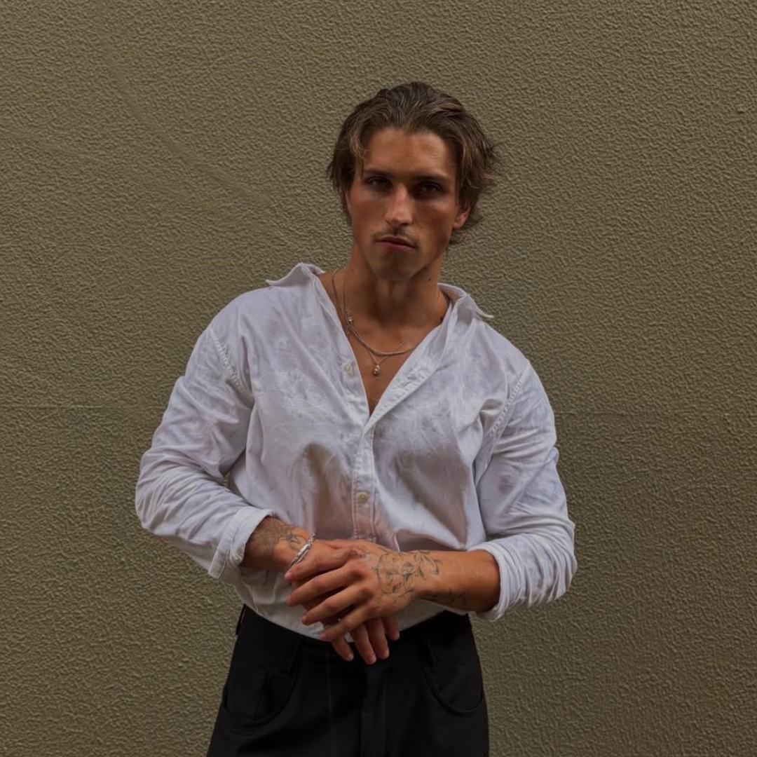 fashion blond man, muscular wearing white button up shirt and monateo jewelry