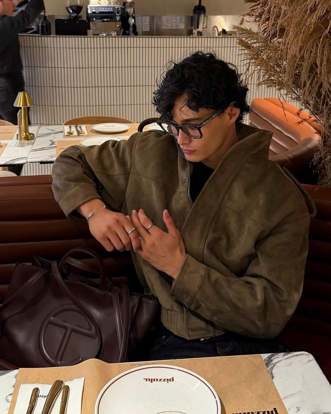 man in a restaurant wearing monateo jewelry